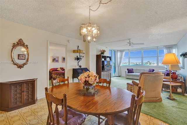 dining space featuring ceiling fan with notable chandelier, light colored carpet, and a textured ceiling