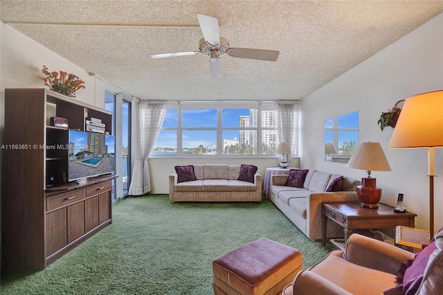 carpeted living room with ceiling fan and a textured ceiling