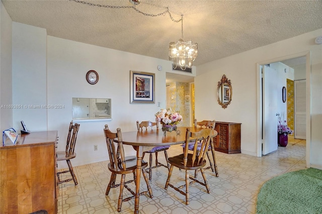 dining space with a notable chandelier and a textured ceiling