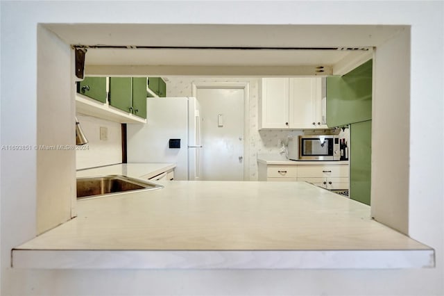 kitchen featuring tasteful backsplash, white cabinetry, sink, and white refrigerator with ice dispenser