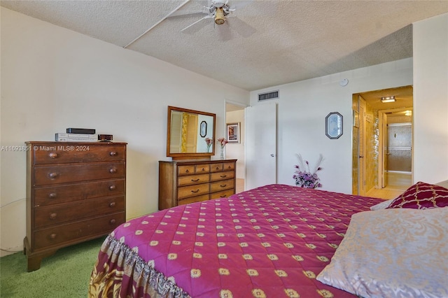 bedroom with carpet, ensuite bathroom, ceiling fan, and a textured ceiling