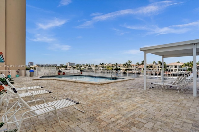 view of swimming pool featuring a water view and a patio