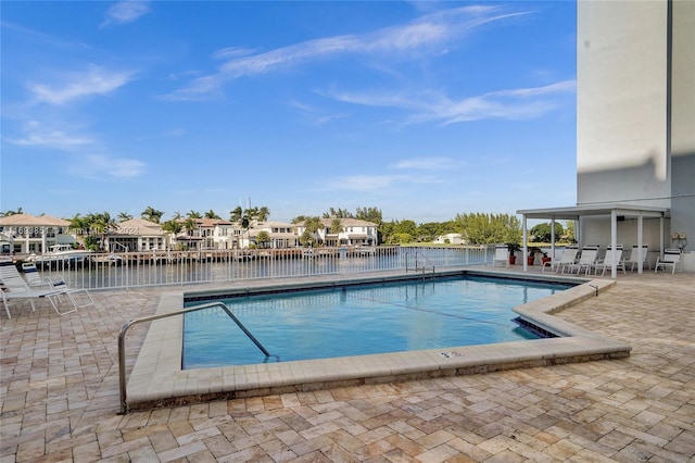 view of swimming pool with a water view and a patio