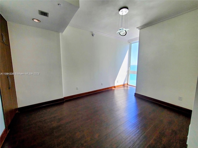 spare room with dark hardwood / wood-style floors and ornamental molding