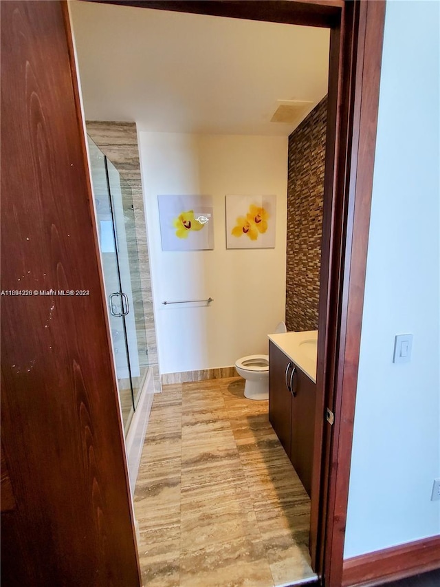 bathroom with vanity, toilet, and a shower with shower door