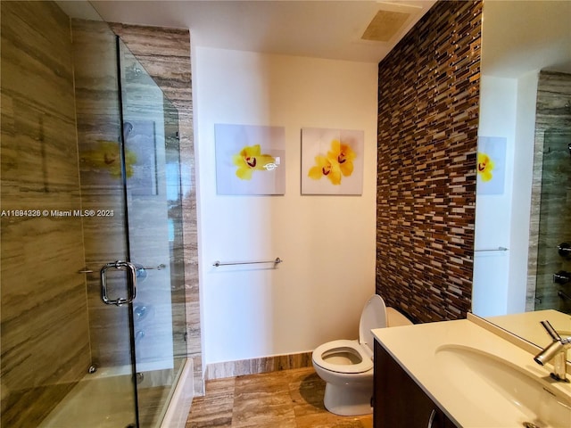 bathroom featuring vanity, toilet, and an enclosed shower