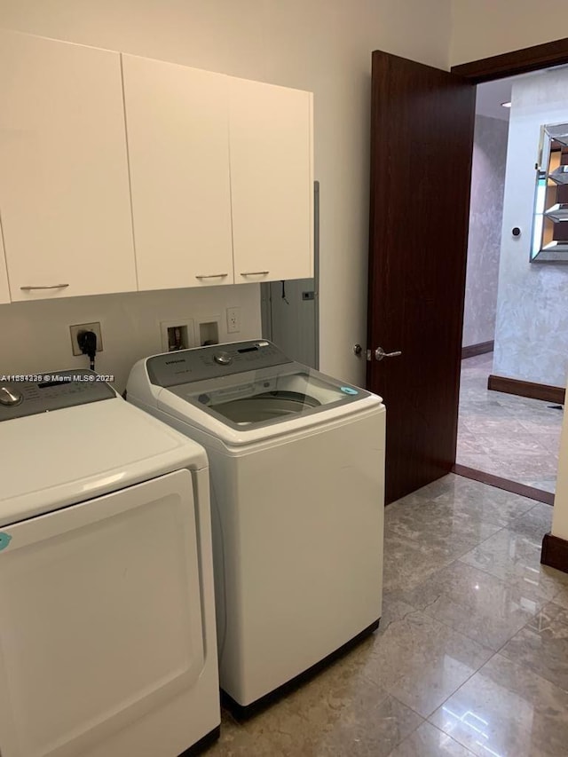 washroom featuring washer and dryer and cabinets