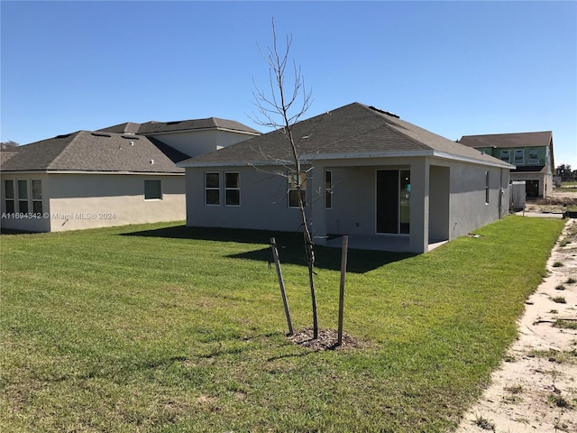 rear view of property featuring a lawn