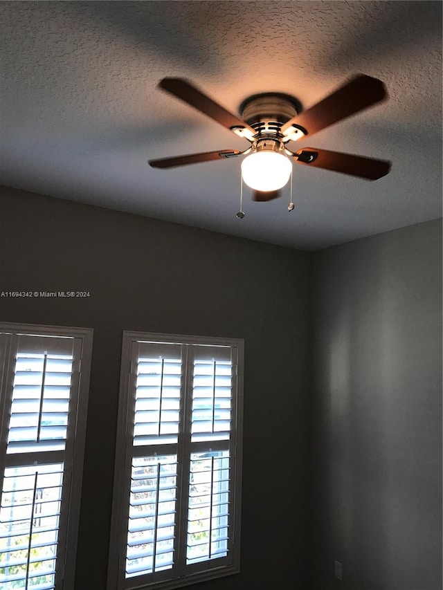 room details featuring a textured ceiling and ceiling fan