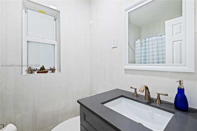 bathroom featuring curtained shower, vanity, and toilet