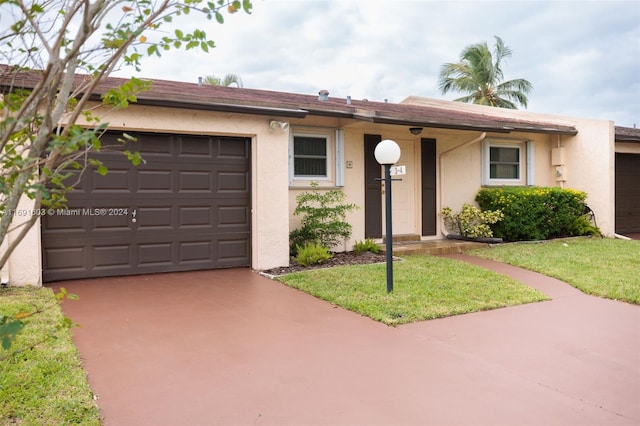 ranch-style home featuring a garage and a front yard