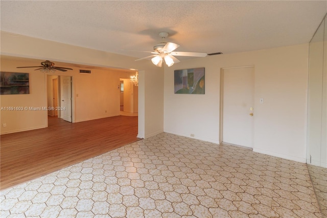 spare room featuring a textured ceiling, light hardwood / wood-style floors, and ceiling fan