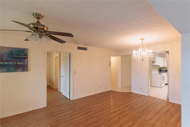 unfurnished living room with a textured ceiling, light hardwood / wood-style floors, and ceiling fan with notable chandelier