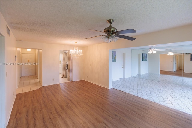 unfurnished room with ceiling fan with notable chandelier, wood-type flooring, and a textured ceiling