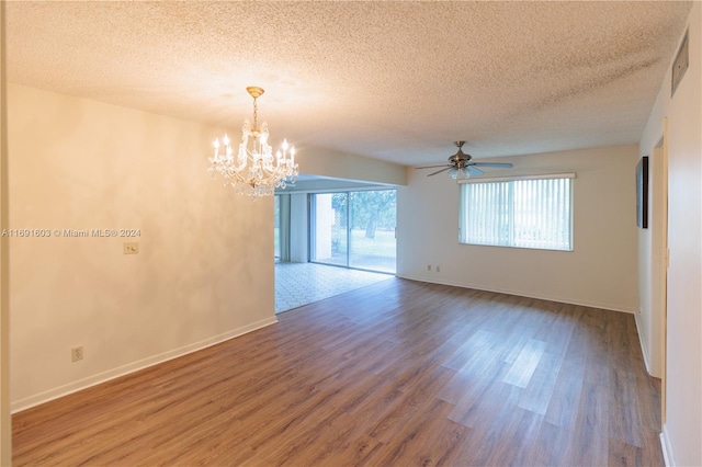 unfurnished room featuring hardwood / wood-style flooring, ceiling fan with notable chandelier, and a textured ceiling