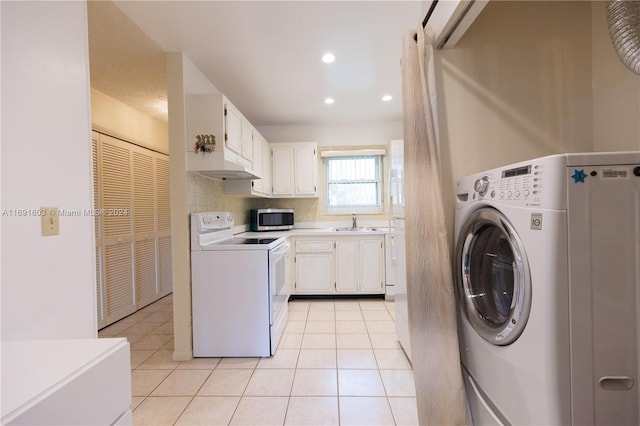 clothes washing area with washer / clothes dryer, sink, and light tile patterned floors