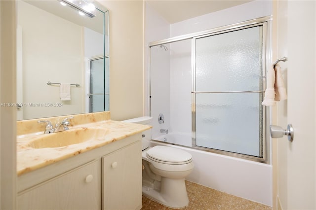 full bathroom featuring combined bath / shower with glass door, vanity, and toilet