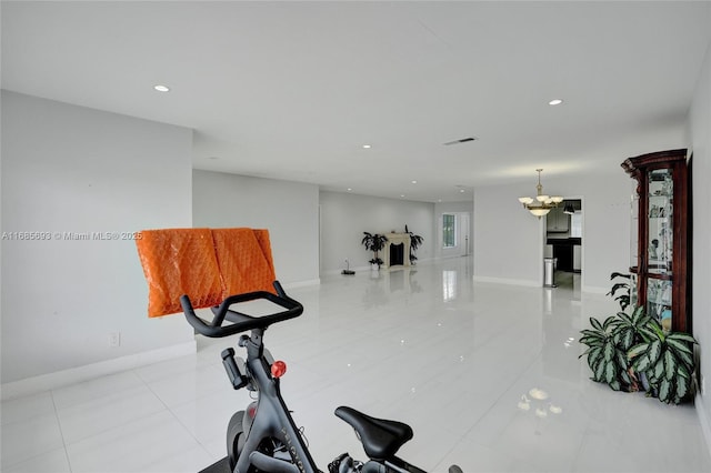 workout room with light tile patterned floors and a notable chandelier