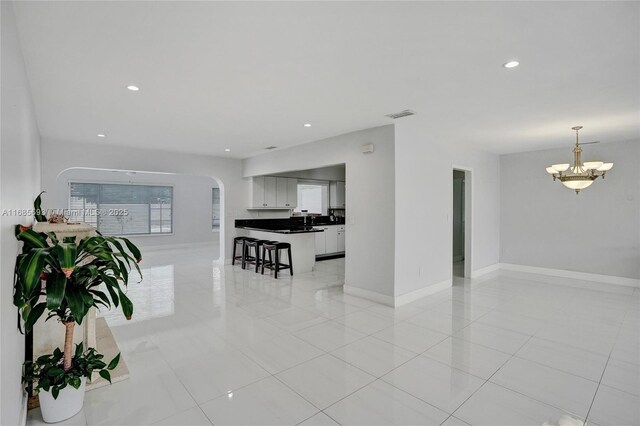 8925 SW 11th St, Miami, FL 33174 - living room featuring arched walkways, light tile patterned floors, baseboards, and recessed lighting