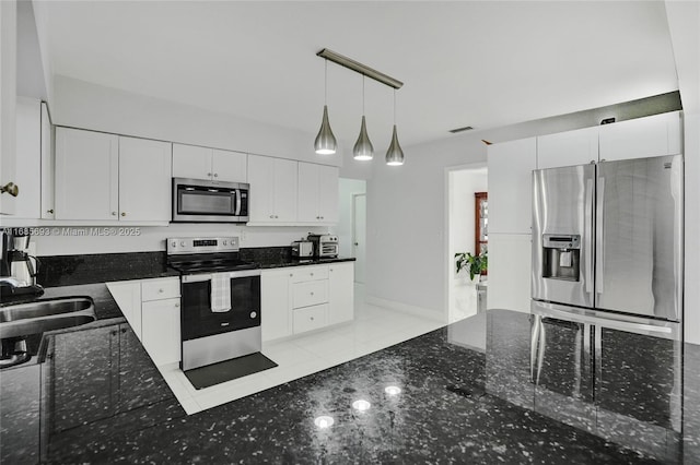 kitchen featuring decorative light fixtures, white cabinetry, sink, dark stone countertops, and stainless steel appliances