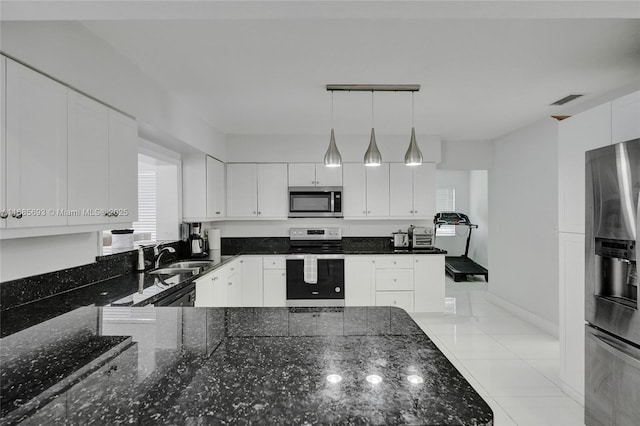 kitchen with sink, appliances with stainless steel finishes, white cabinetry, decorative light fixtures, and dark stone counters