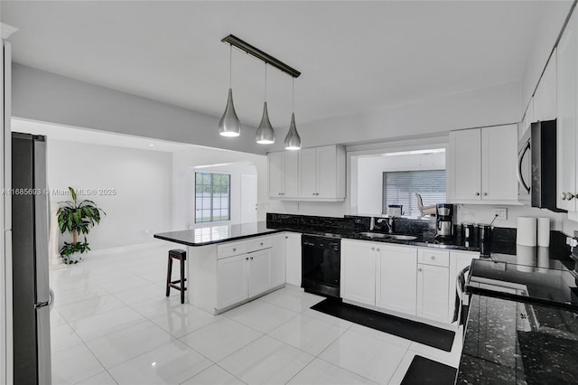 kitchen featuring appliances with stainless steel finishes, pendant lighting, white cabinetry, sink, and kitchen peninsula