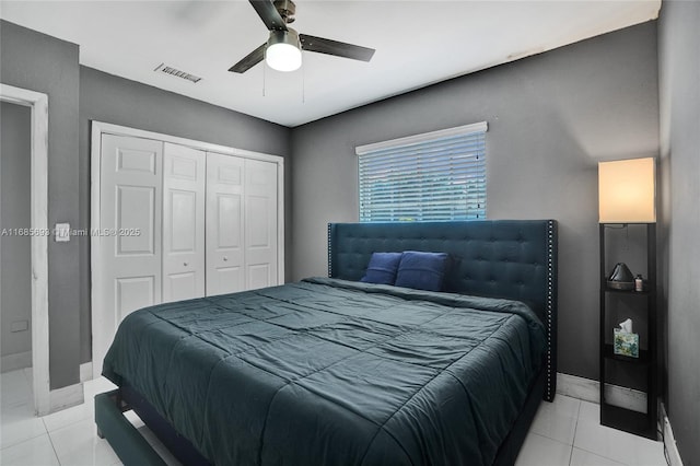 tiled bedroom with ceiling fan and a closet