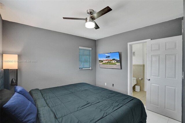 bedroom featuring ceiling fan, ensuite bathroom, and light tile patterned floors