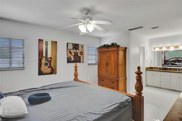 bedroom with ceiling fan, sink, and ensuite bath