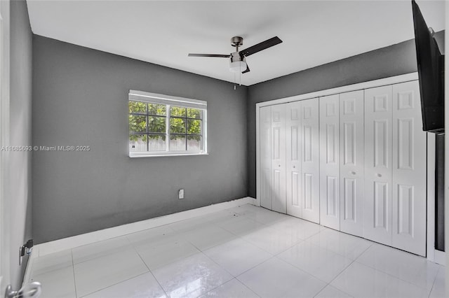 unfurnished bedroom featuring light tile patterned flooring, ceiling fan, and a closet