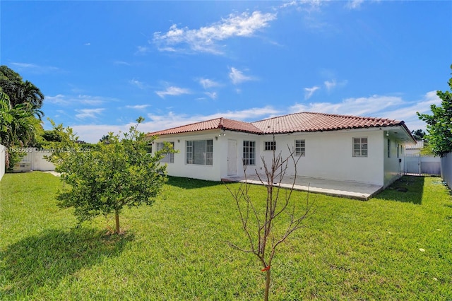 back of house with a patio and a lawn