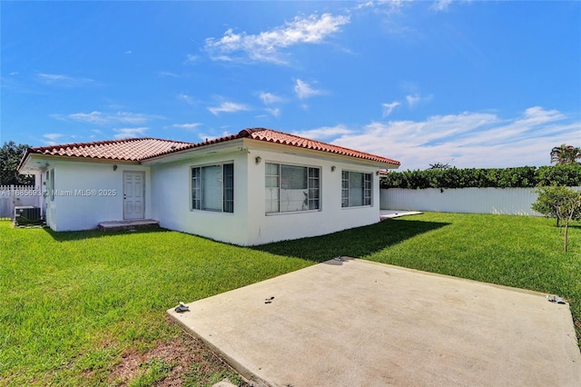 rear view of property with cooling unit, a lawn, and a patio