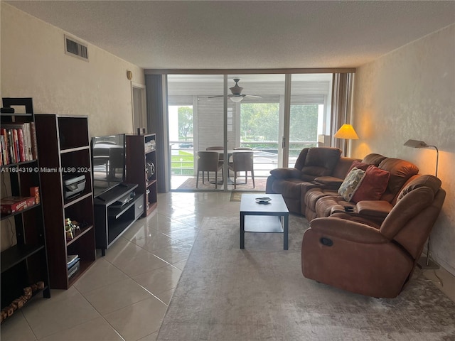 tiled living room featuring ceiling fan and a textured ceiling