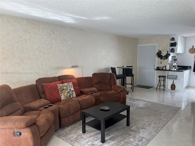 tiled living room featuring a textured ceiling