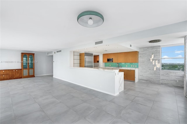 unfurnished living room featuring light tile patterned floors and sink