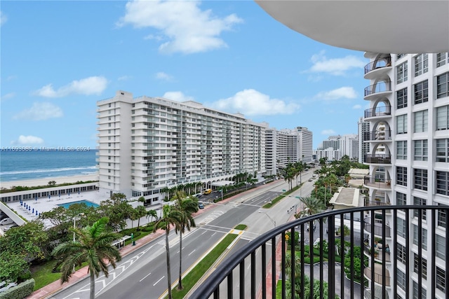 balcony featuring a water view and a beach view