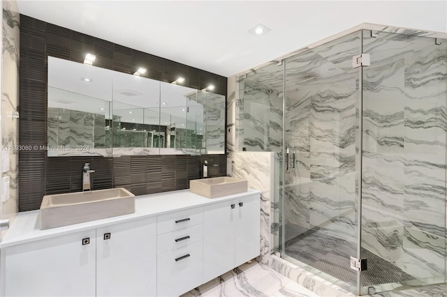 bathroom featuring a shower with door and vanity