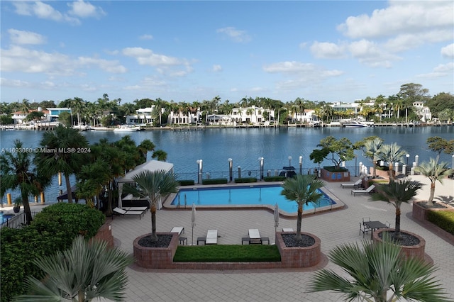 view of swimming pool with a water view and a patio