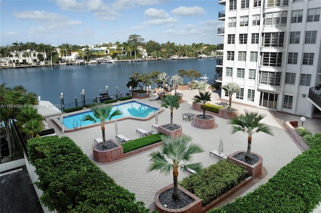 view of pool with a patio and a water view