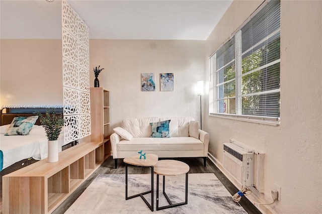 sitting room featuring a wall mounted AC and hardwood / wood-style flooring