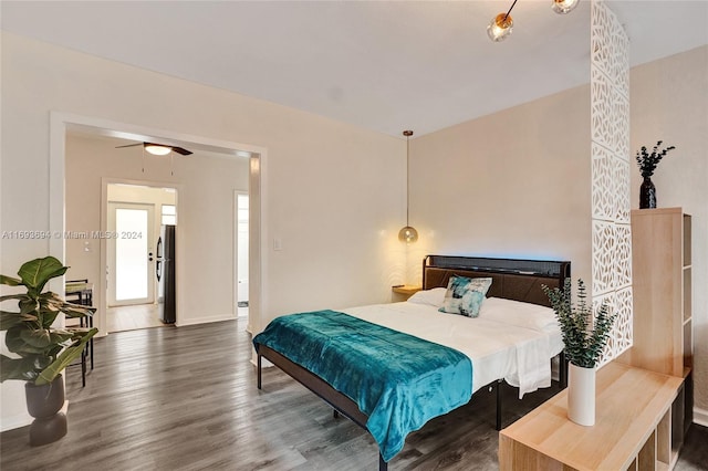 bedroom with stainless steel fridge, ceiling fan, and dark wood-type flooring