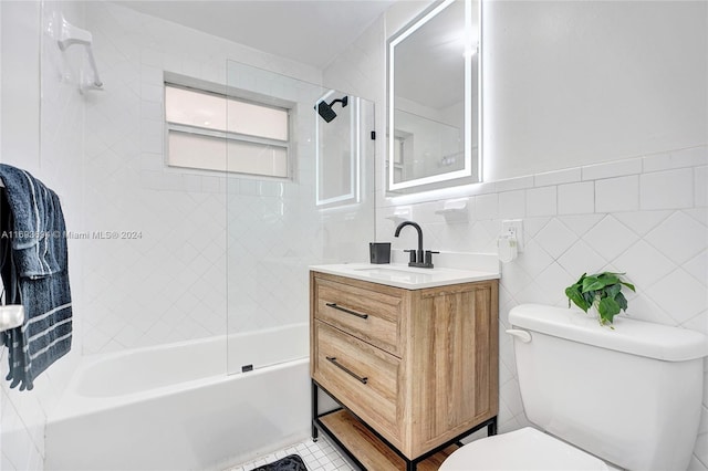 full bathroom with tile patterned floors, vanity, tile walls, toilet, and tiled shower / bath