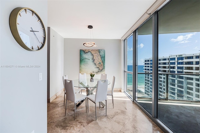 dining space with a water view and a wall of windows