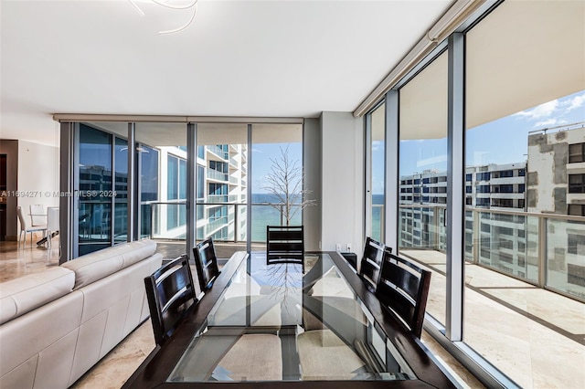 dining space featuring expansive windows and a water view