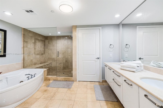 bathroom featuring plus walk in shower, vanity, and tile patterned floors