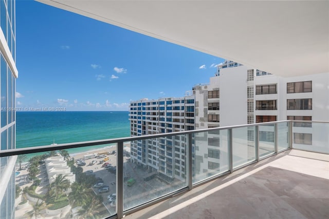 balcony featuring a view of the beach and a water view