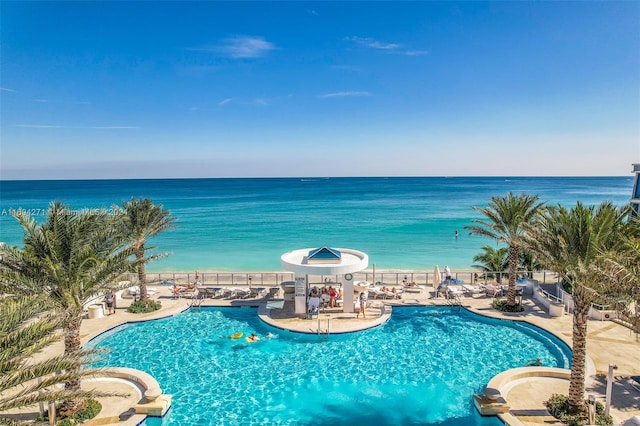 view of pool featuring a water view and a patio