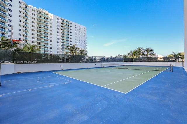 view of tennis court featuring basketball hoop