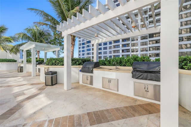 view of patio / terrace featuring an outdoor kitchen, area for grilling, a pergola, and sink