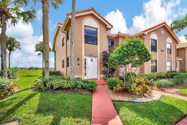 mediterranean / spanish-style home with a front yard